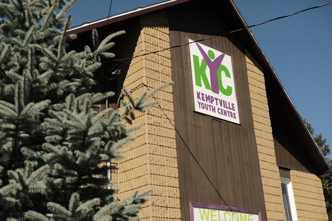 The Kemptville Youth Centre building, with its sign visible beside evergreen trees